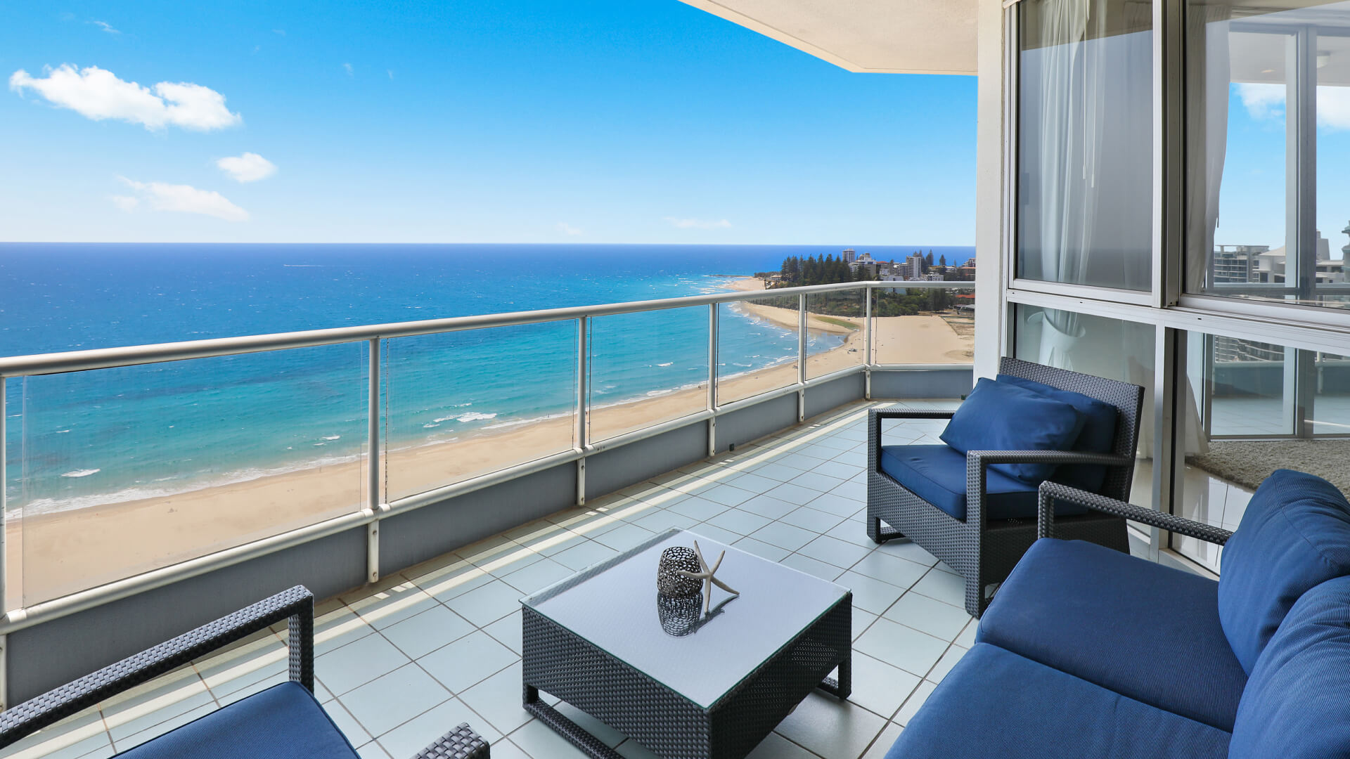 Spacious balcony of the ULTIQA Points North penthouse with outdoor seating and panoramic ocean views over Coolangatta Beach.