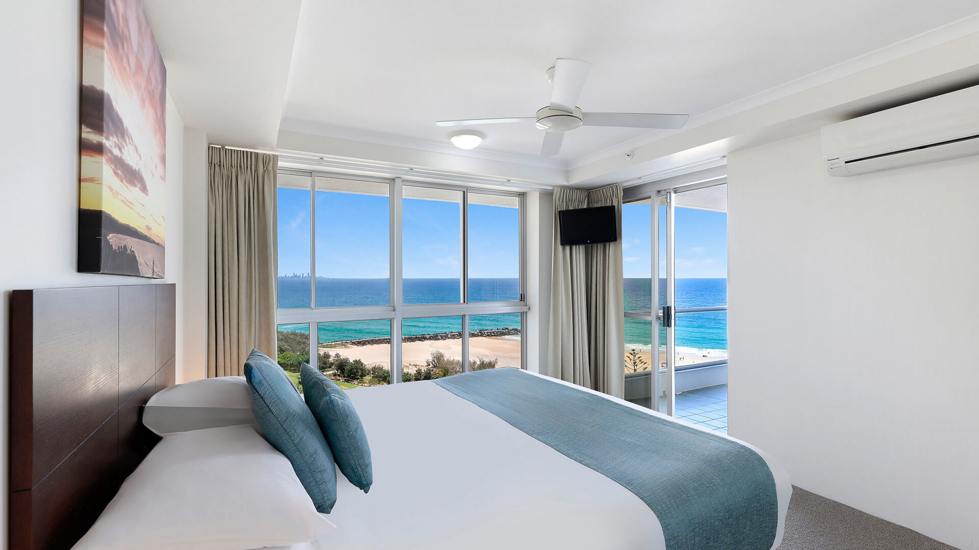 Main bedroom in the Deluxe 2 Bedroom Centre Front Apartment at ULTIQA Points North with oceanfront views and balcony access.