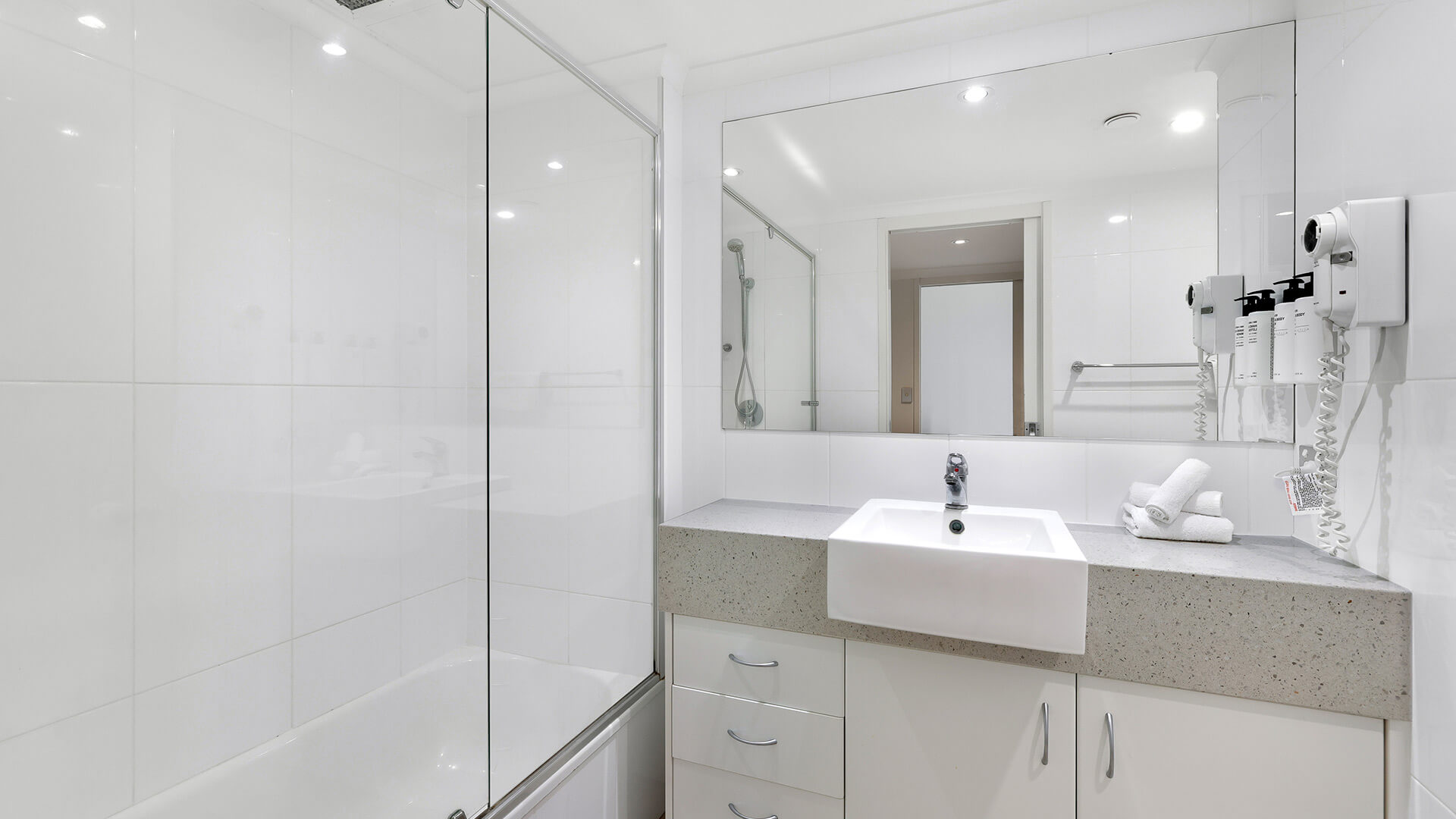Bright modern bathroom with shower-over-bath in the Deluxe 2 Bedroom Centre Front Apartment at ULTIQA Points North.