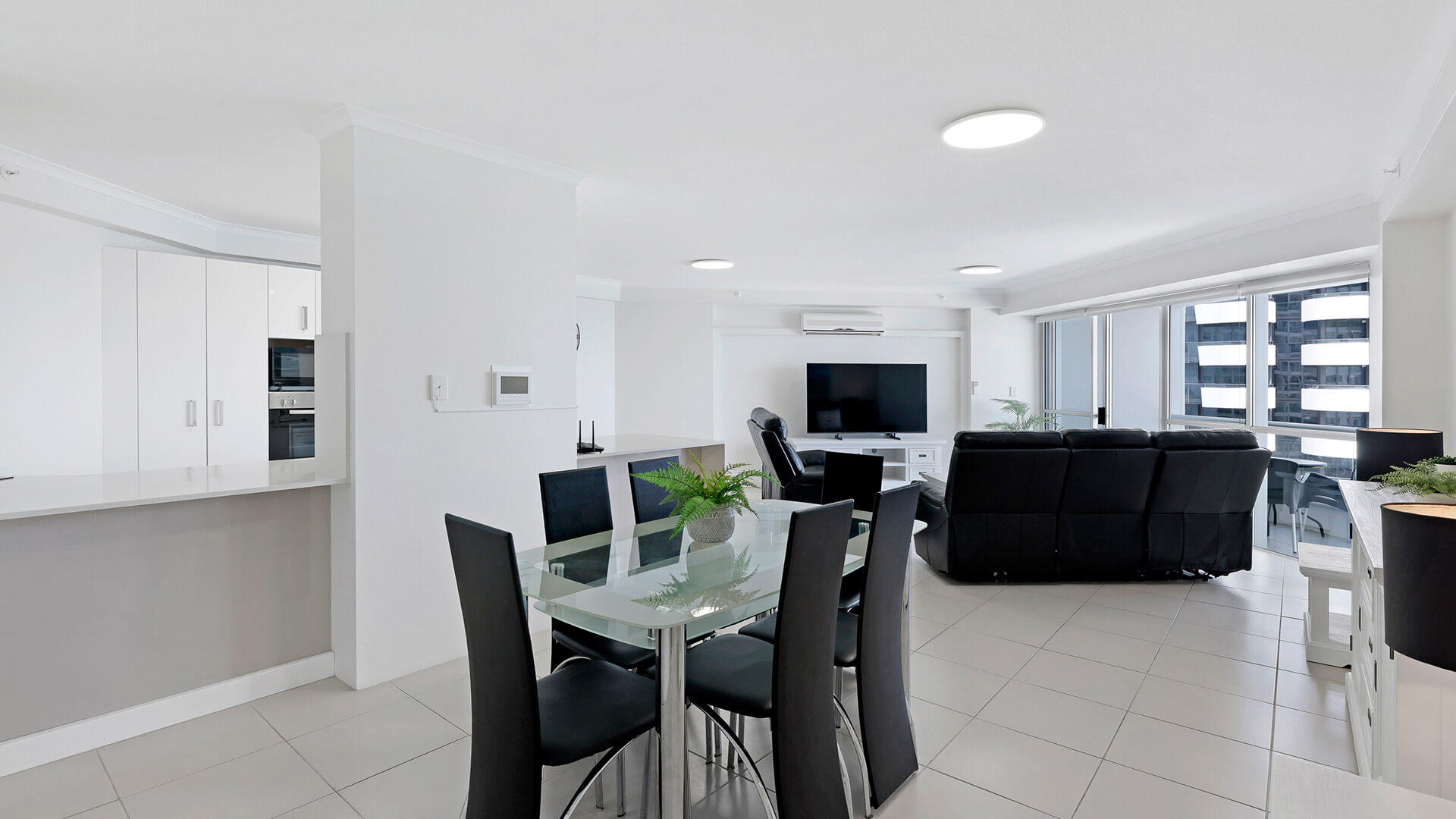 Modern white kitchen in the 2 Bedroom Superior Ocean View Apartment featuring ample cabinetry, tiled floors, and full appliances.